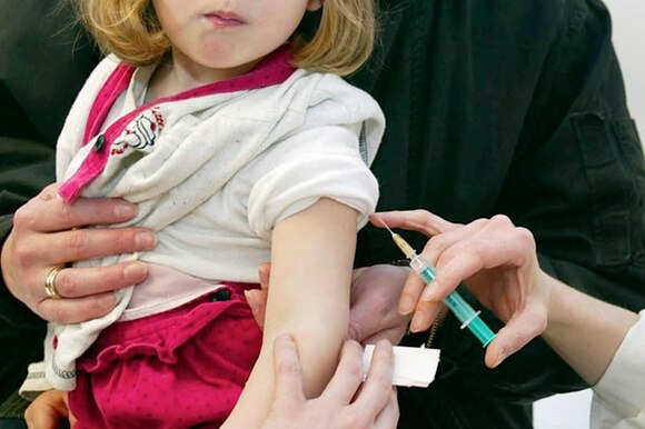 Immagine di una bambina cui viene praticata una vaccinazione.