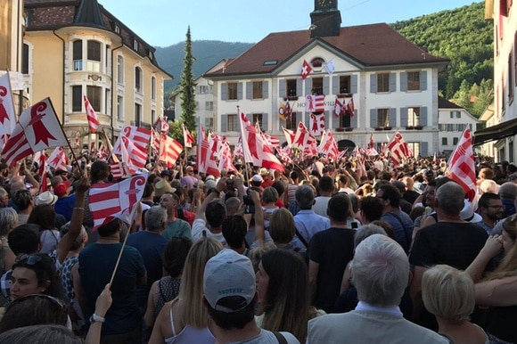 Una folla che sventola bandiere giurassiane davanti al municipio di Moutier.