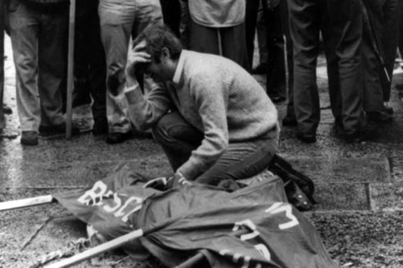 Il corpo di una delle vittime della strage di Piazza della Loggia a Brescia coperto da uno striscione, 28 maggio 1974.