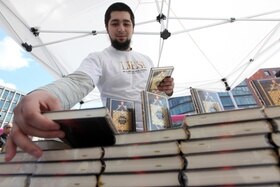 Un ragazzo dispone dei libri del Corano su uno stand