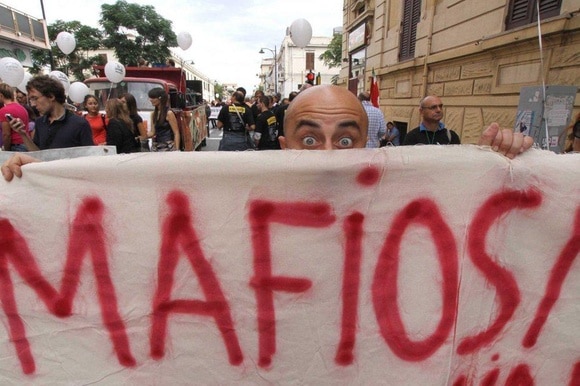 striscione con la scritta mafiosi esposto durante una manifestazione a Reggio Calabria
