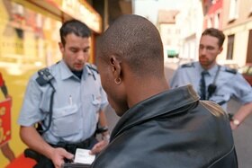 Une personne noire contrôlée par deux policiers