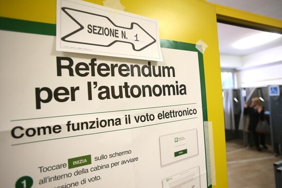 Un cartello riporta le istruzioni del voto elettronico in Lombardia