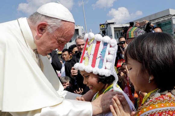 Papa Francesco incontra una ragazza all aeroporto di Yangon, in Myanmar, vestita con abiti tradizionali