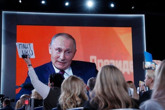 Il volto di Vladimir Putin su maxischermo durante la tradizionale conferenza stampa di fine anno.