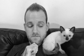 Robert Woodrich con il suo gatto siamese sulla spalla