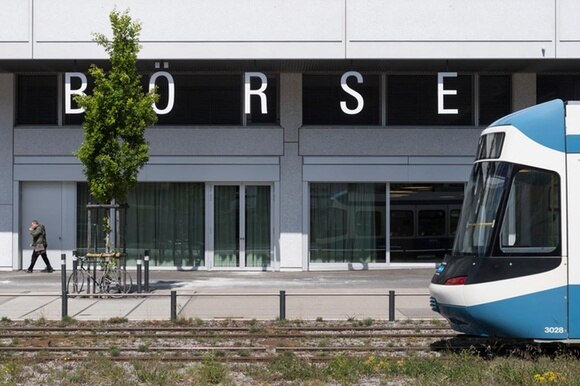 Immagine di alcune vetrate del piano terra della Borsa svizzera, con gli antistanti binari del tram, che sopraggiunge