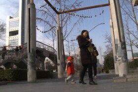 Immagine di una mamma con bambino che passeggia per Pechino in un giorno di bel tempo