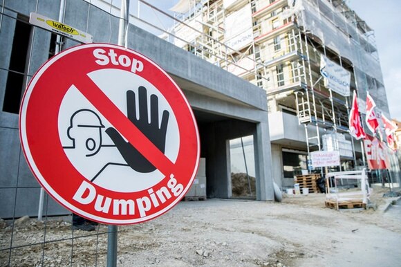 cartello davanti a un cantiere con la scritta Stop Dumping