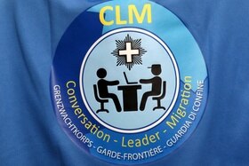 Logo dei CLM (personale specializzato che intervista i migranti) ritratto in primo piano sulla mantellina che indossano
