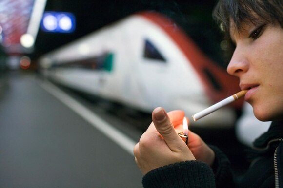 Una ragazza si sta accendendo una sigaretta.