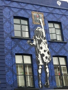 Una casa a Portobello Road a Londra con la facciata decorata di blù e il disegno di una bambina che si arrampica.