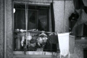 Balcone con panni stessi e materiale vario depositato fuori dalla porta finestra