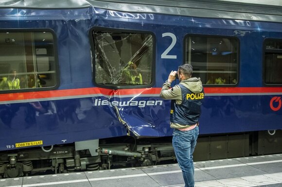 Un poliziotto fotografa il convoglio demolito dallo scontro nella stazione di salisburgo