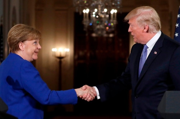 Trump e Merkel si stringono la mano.