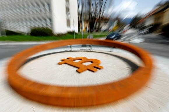 Cars pass a roundabout with the allegedly world s first Bitcoin monument in Kranj, Slovenia