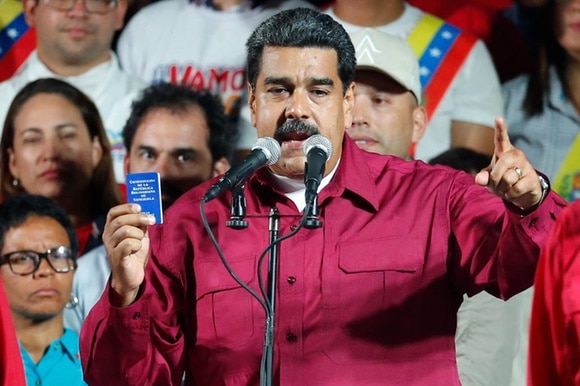Maduro con in mano la costituzione venezuelana durante il discorso dopo la dichiarazione ufficiale della sua vittoria.