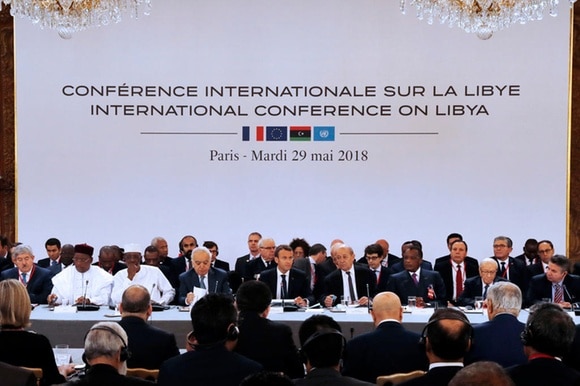 Delegati riuniti a parigi - scritta: Conferenza internazionale sulla Libia