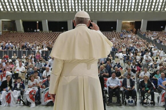 il papa su un palco saluta la folla.
