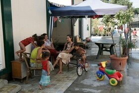 gruppo di donne e bambini rom seduti all esterno di un edificio