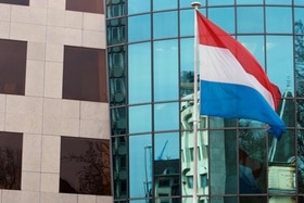 bandiera di colore rosso, bianco e blu sventola davanti a un edificio vetrato