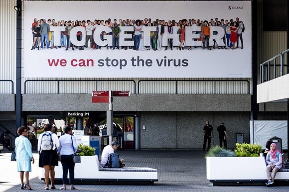 Lo slogan Possiamo fermare il virus accoglie i partecipanti al congresso di Amsterdam