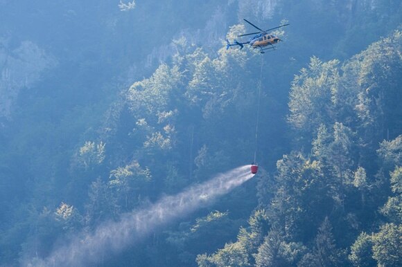 Elicottero dei pompieri in azione per spegnere l incendio provocato dal crash aereo a Hergiswil