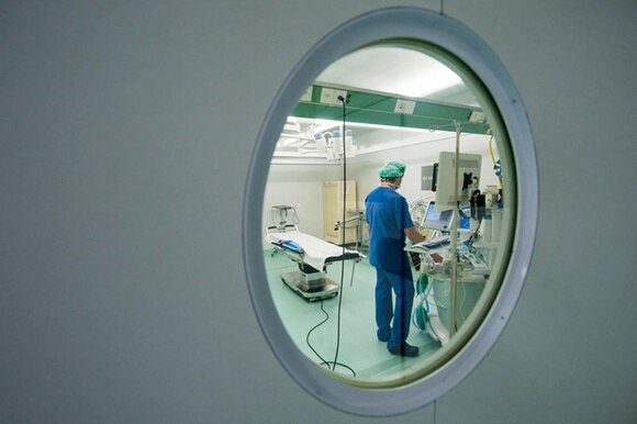 chirurgo fotografato dall oblò della porta di una sala operatoria