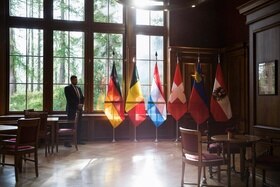 Bandiere di Germania, Belgio, Lussemburgo, Svizzera, Austria e Liechtenstein esposte all entrara di una sala con interni in legn