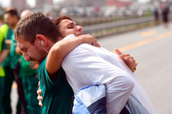 L abbraccio di due persone durante la commemorazione a un mese dal crollo del ponte a Genova