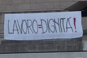 Uno striscione che cita lo slogan lavoro=dignità