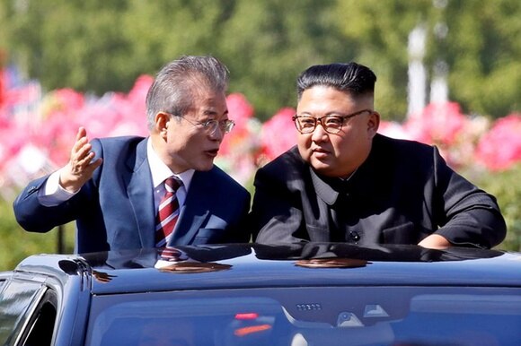 I due leader salutano dall auto scoperta nel perscorso che dall aeroporto li ha portanti nella capitale Pyongyang