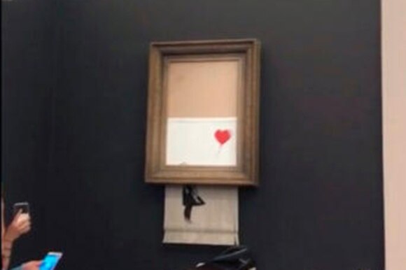 Il dipinto di Banksy che scende dalla cornice e viene mangiato dal tritadocumenti