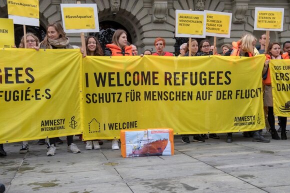 Persone, manifesti con la scritta I welcome refugees
