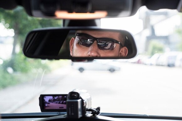volto di un automobilista riflesso nello specchietto retrovisore