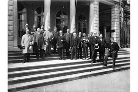 Gruppo di uomini posa per una foto di gruppo sulla scalinata davanti a un edificio con colonnato