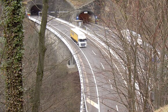 Fotao dall alto di un camion esce da una galleria e imbocca un viadotto sull autostrada