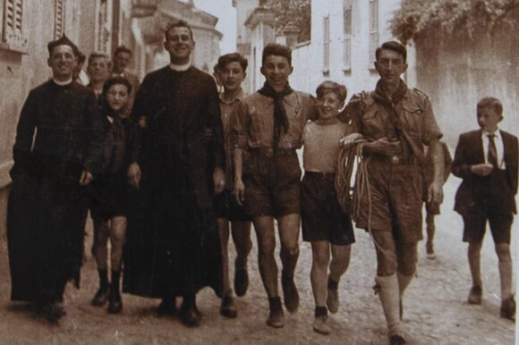 Foto d epoca con un gruppo di ragazzi scout e due preti
