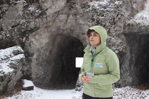 donna davanti a una caverna