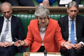 Primo piano di Theresa May che si rivogle alla Camera dei Comuni.