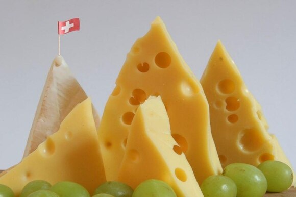 4 pezzi di formaggio Emmentaler e uno di parmigiano disposti in modo che raffigurano vette di montagne.