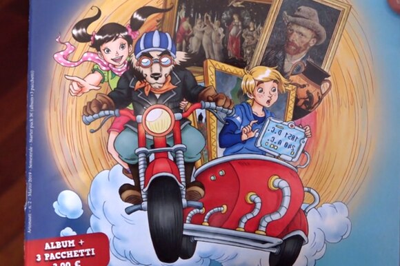 Primo piano della copertina di un fascicolo in carta patinata con due personaggi in moto/sidecar che trasportano quadri