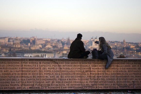 due persone sedute su un muro