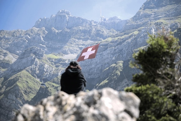 Persona di spalle guarda bandiera svizzera