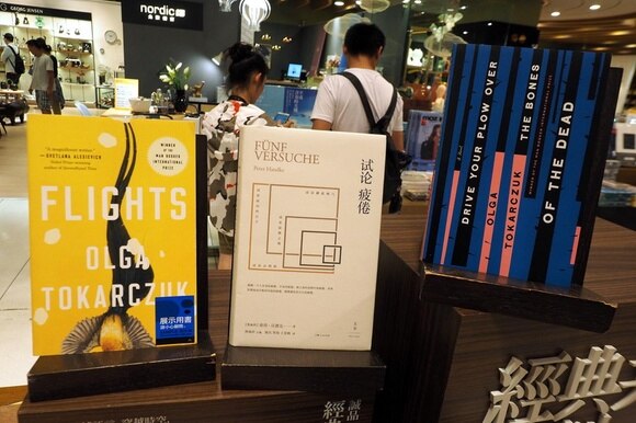 Primo piano di un espositore di libri in un negozio con insegne in ideogrammi cinesi tradizionali