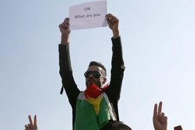 Unuomo curdo con un cartello in mano con scritto in inglese: Onu, dove sei?