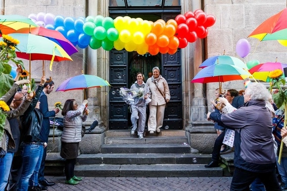 Una coppia gay festeggiata davanti a una chiesa.