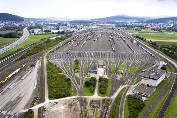 Veduta aerea di un ampia spianata con binari ferroviari che si sdoppiano fino a raggiungere le 64 unità