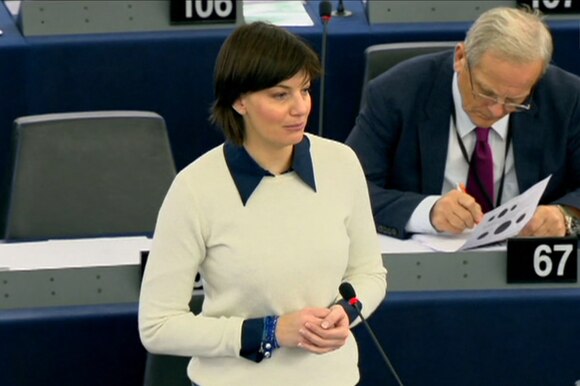 Lara Comi in maglione bianco e colletto blu, mani conserte, durante un intervento all europarlamento