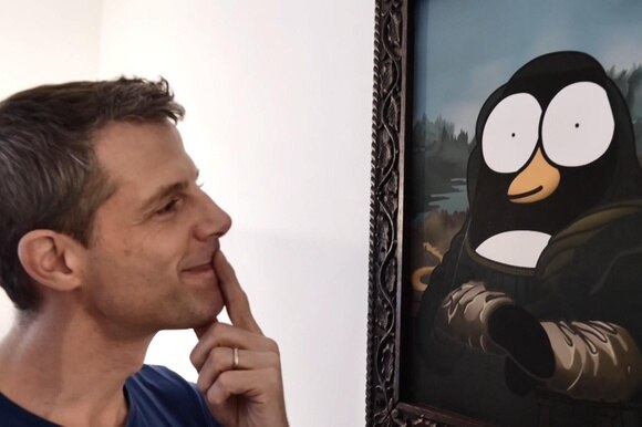 massimo fenati guarda un quadro con un pinguino